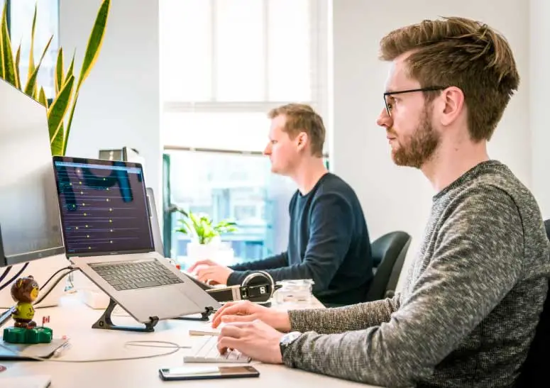 two men working side by side in a workspace